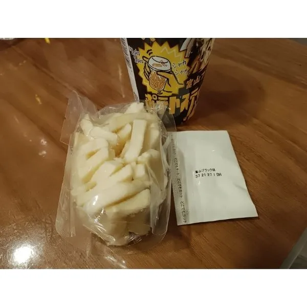 富山ブラック しゃかしゃかポテトスティックとシーズニングをカップから取り出した写真
